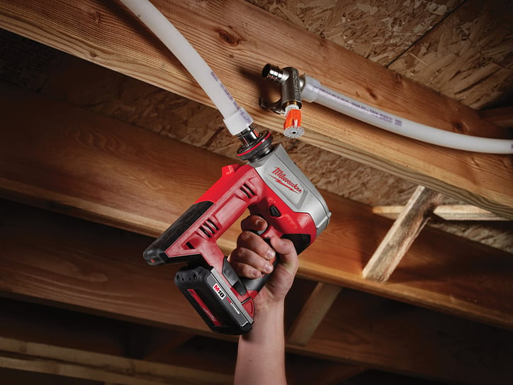 A plumber using the M18 ProPEX Expansion Tool