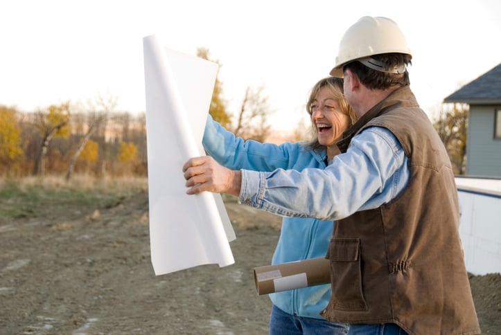 Architect shows bulding plans to happy customer