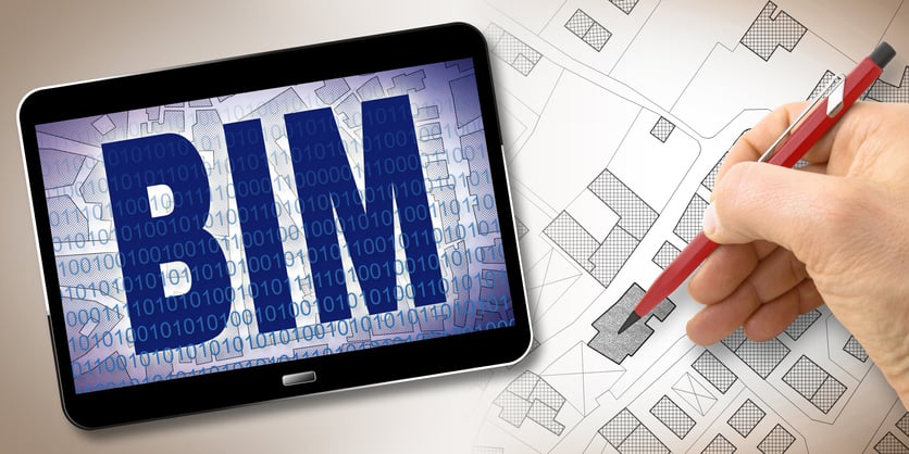 A building information modeling specialist sketches housing design beside iPad featuring BIM software