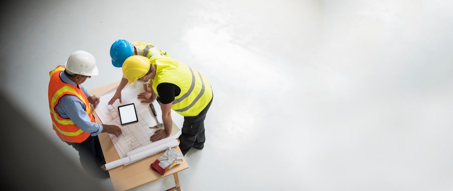 Construction project manager consults with workers over drawings