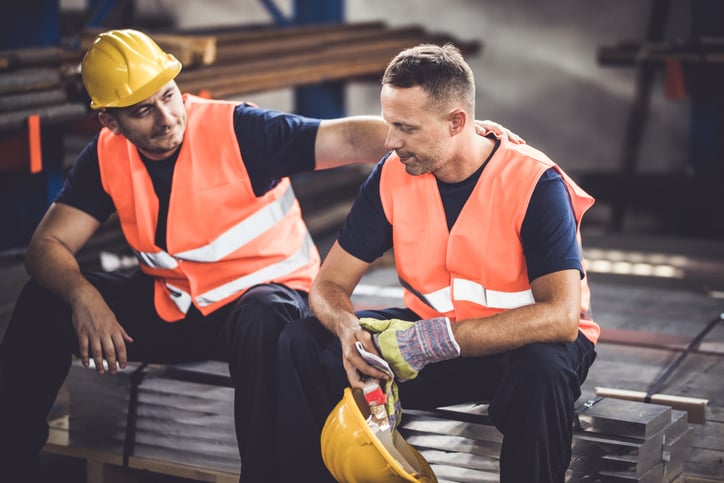 Construction worker consoling coworker