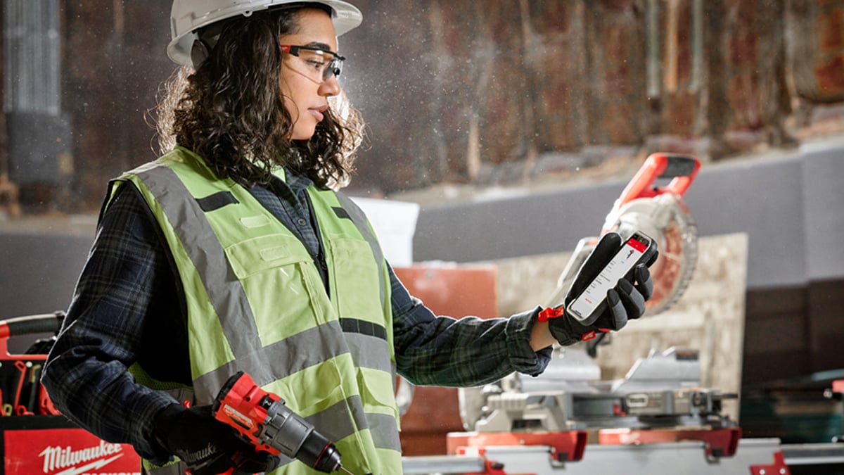 Female contractor connects to Milwaukee smart drill on One-Key app