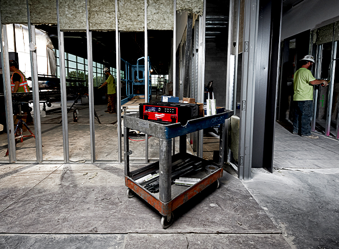 A cart in the center of a construction jobsite holds tools