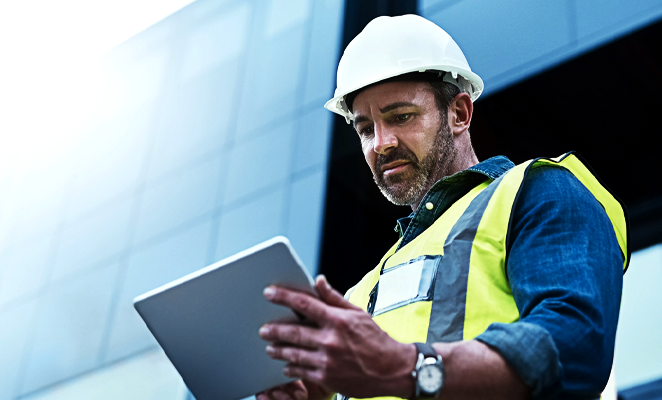 A construction manager views project details on a mobile tablet device