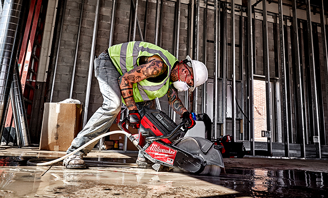 A tradesman uses the MX FUEL cut off saw to cut through concrete