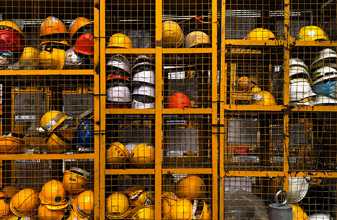 A tool crib is stocked with unused construction helmets during the day