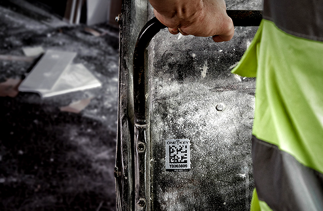 man wheels cart with large item tagged with identification sticker