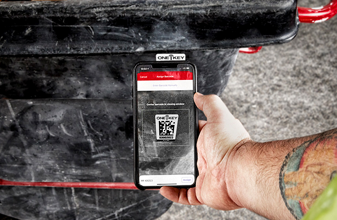 smartphone camera scans an asset ID tag on a wheeled garbage bin