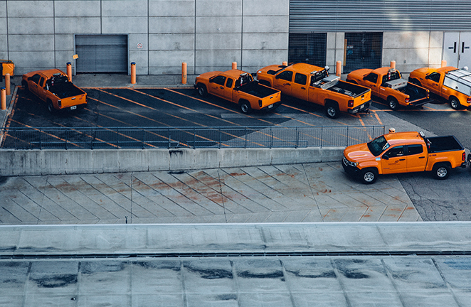 A fleet of orange pickup trucks