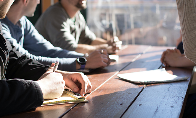 A construction project management team at the back office seated at a table amid conversation