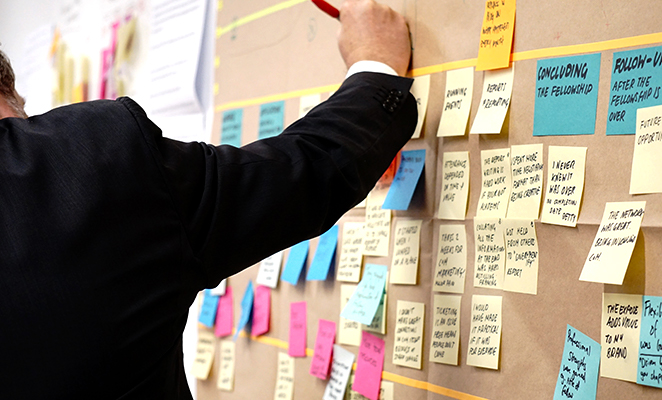 A construction project manager outlines project timelines on a cork board