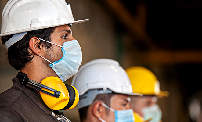 Construction workers in hard hats wear surgical face masks during COVID-19 pandemic