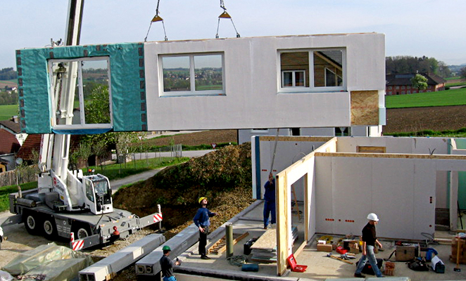 Construction workers on jobsite install prefabricated building components