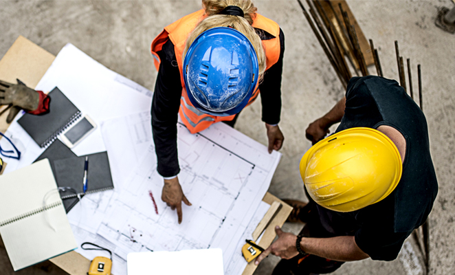 Construction workers discuss building plans together