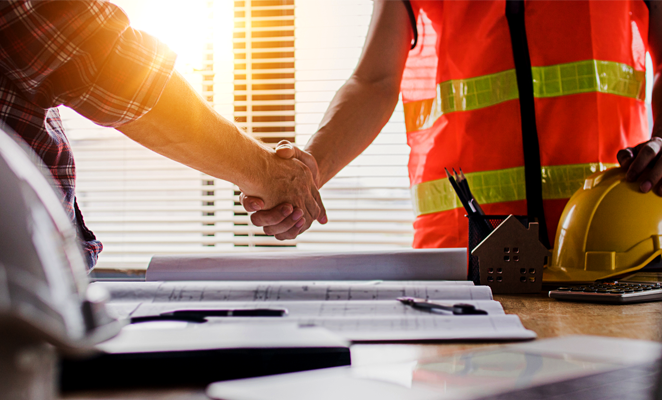 Owner-operator and subcontractor shake hands over design plans