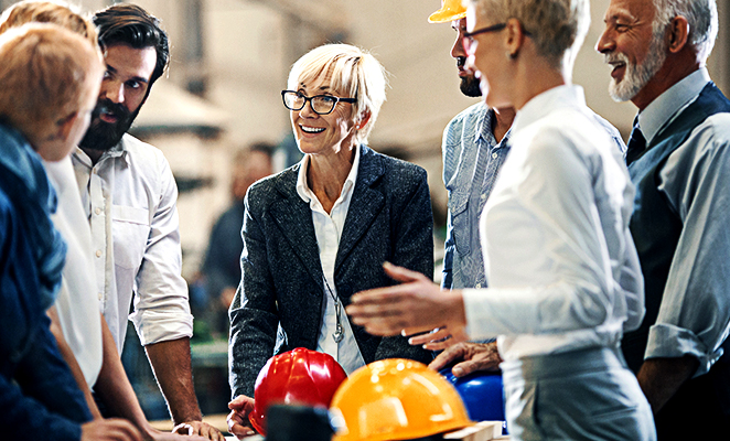 A group of contractors and customers meet, discussing construction plans over desk