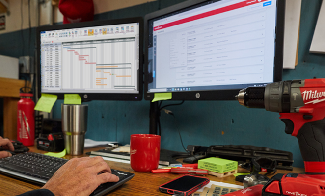 An inventory manager in tool room views spreadsheet and One-Key enterprise construction tool tracking inventory system