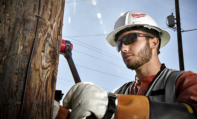 A lineman adjusting cable with ratchet wrench