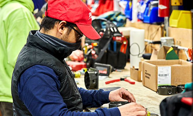 Tool crib attendant wearing gaitor conducting inspection