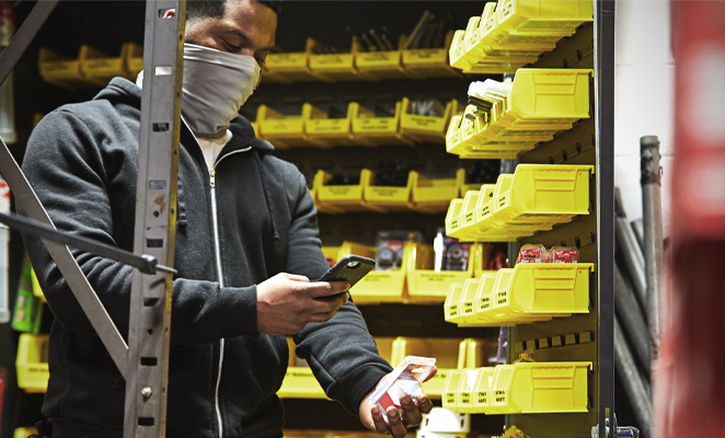 A tool room attendant scans bardcode with smartphone