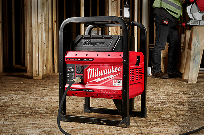 Milwaukee's MX FUEL cordless power supply in jobsite recharging tool battery while contractor operates cordless table saw