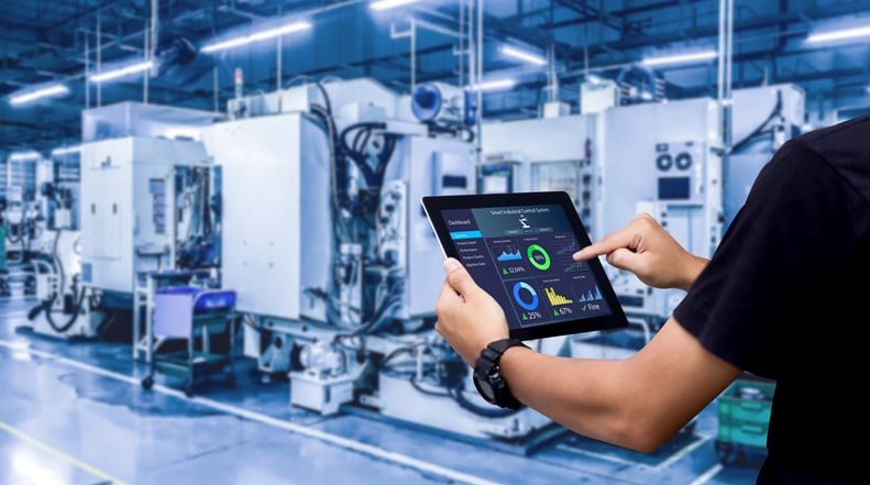 Manufacturing tech in warehouse using iPad to assess productivity