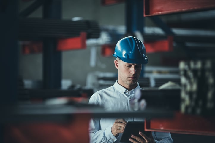 Mid adult foreman working on digital tablet in aluminum mill