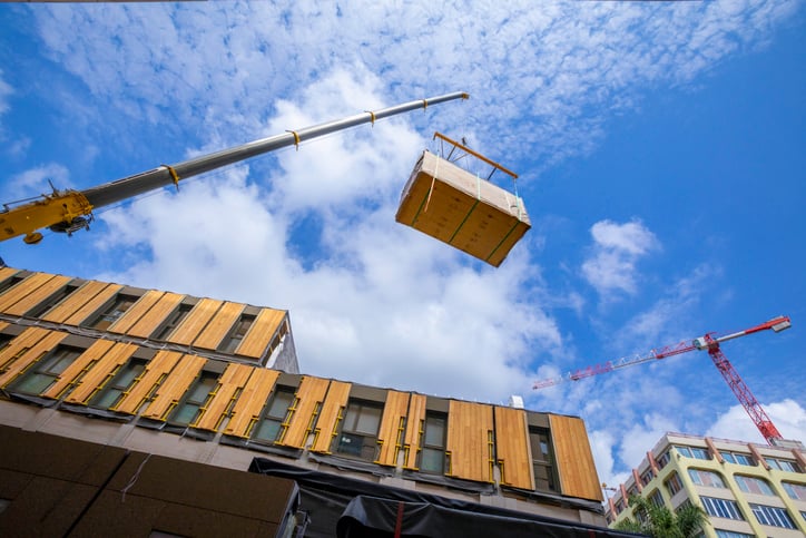 Pre-fabricated modular wood commercial building being assembled with crane stock