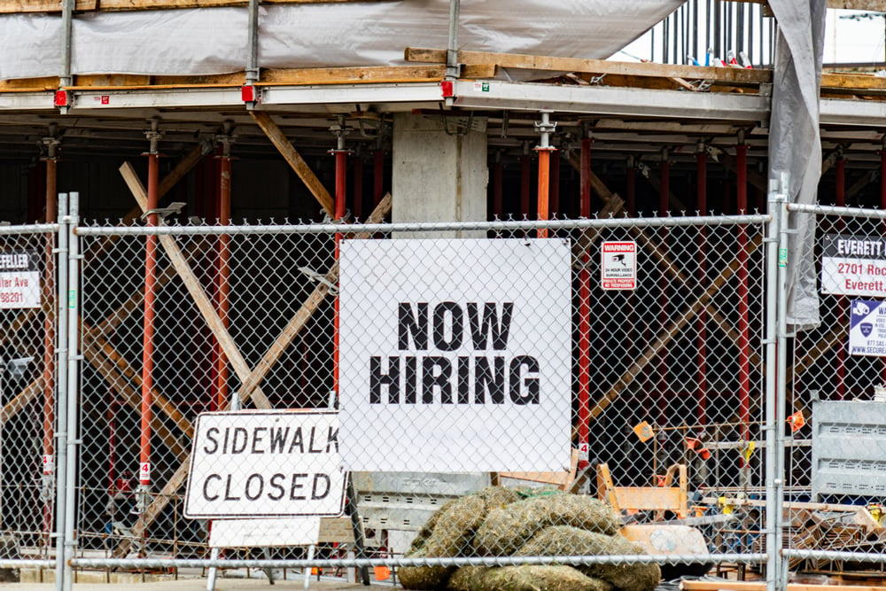 closed-construction-site-with-now-hiring-sign
