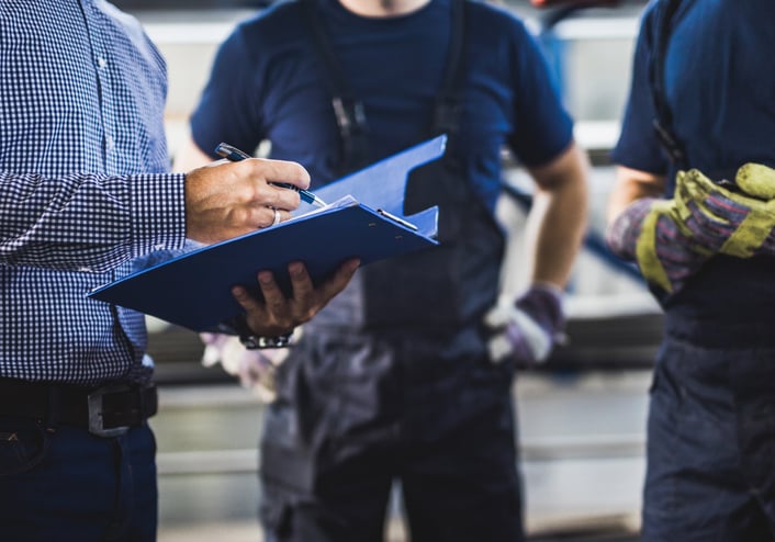 A construction and building inspector reviews results with two tradesmen