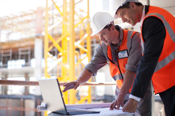 construction-workers-on-jobsite-looking-at-laptop