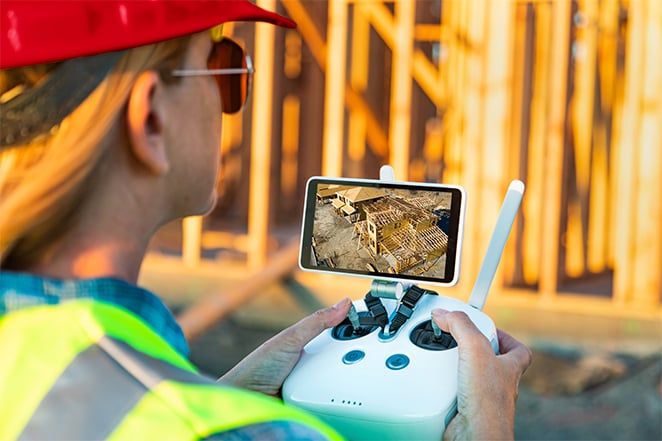 A contractor uses a remote control to operate construction drone