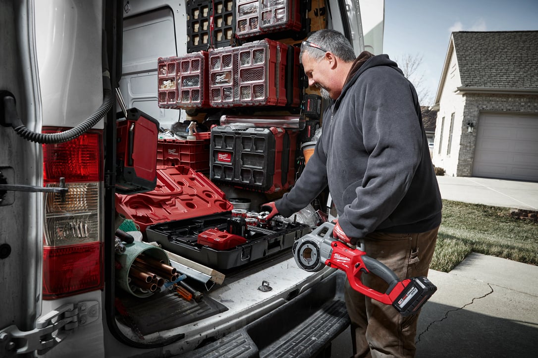 contractor-with-pipe-threader-beside-organized-work-van