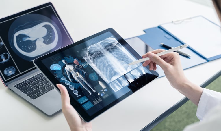 doctor examines scan of patients abdomen on tablet device