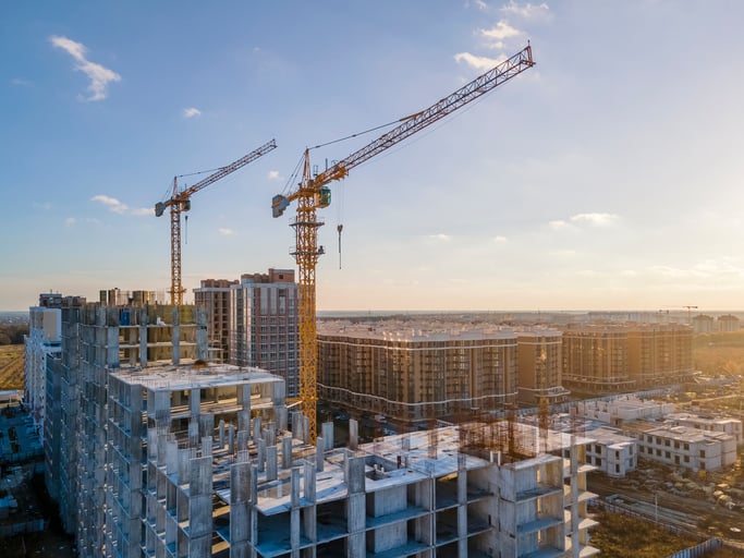 Photo of a crane looming over an empty construction site.