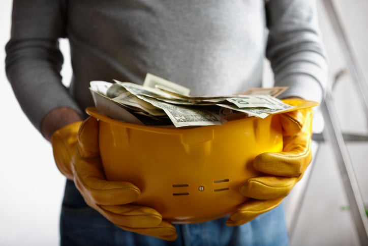 A construction helmet filled with cash
