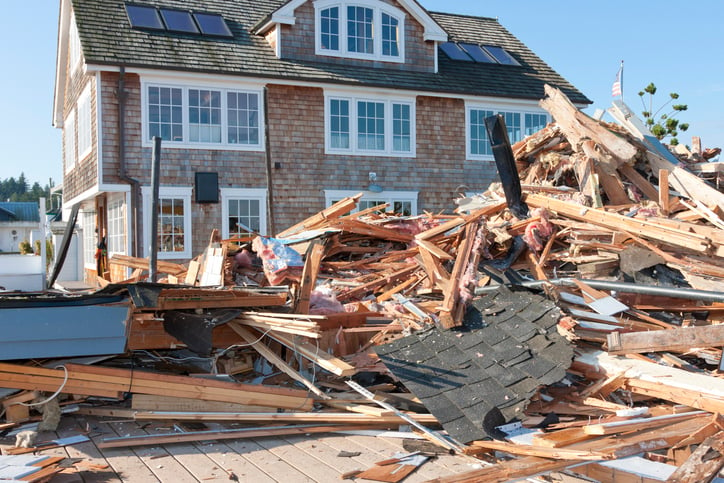 Photo of construction debris in front of a residential building.