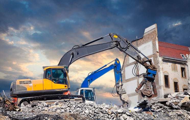 Construction machinery combing through debris.