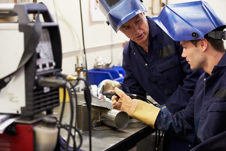 A metalworking trade mentors apprentice in welding and fabrication