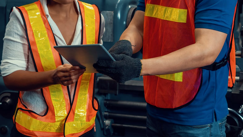 Safety inspector with iPad trains personnel