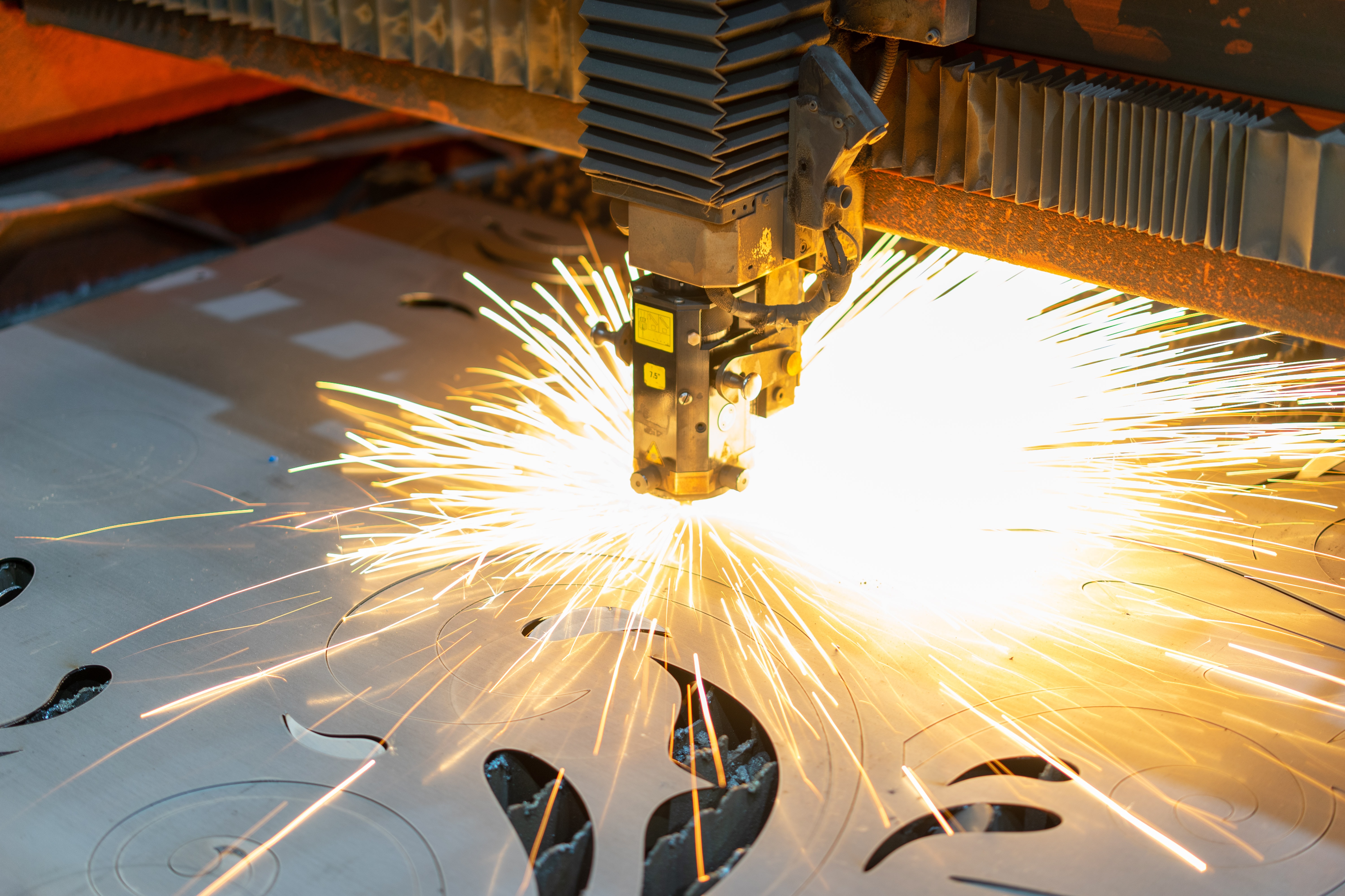 A welding robot in prefab shop cuts out precise shape in sheet metal