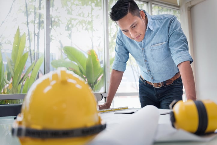 A young BIM specialist examines building plans