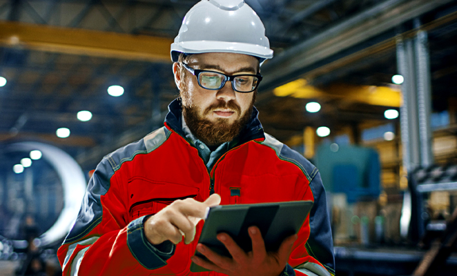 A construction technologist on a work site utilizes a digital tablet to access project information