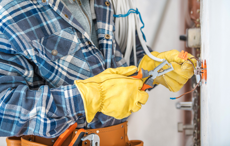 A commercial electrician strips wire